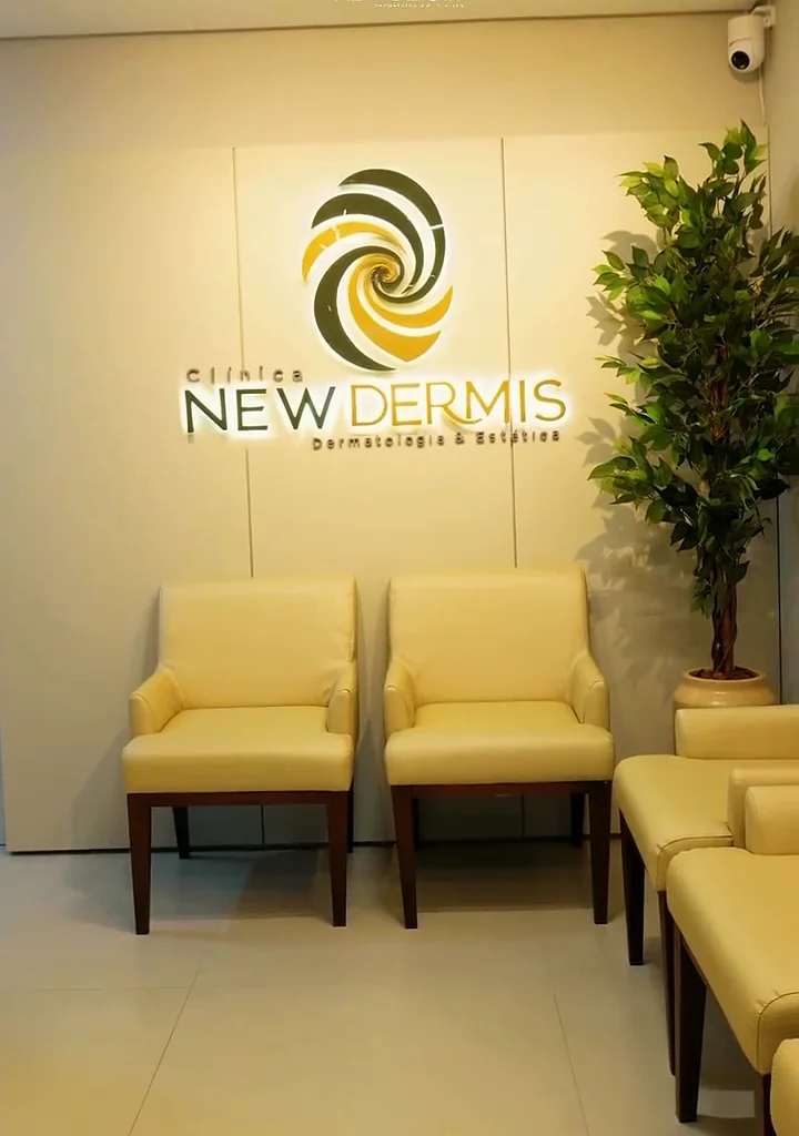 Recepção com poltronas amarelas e o logo da New Dermis na parede
